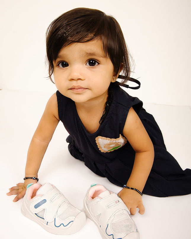 White toddler sneakers with pink lining, blue accent and Velcro straps – lightweight baby shoes